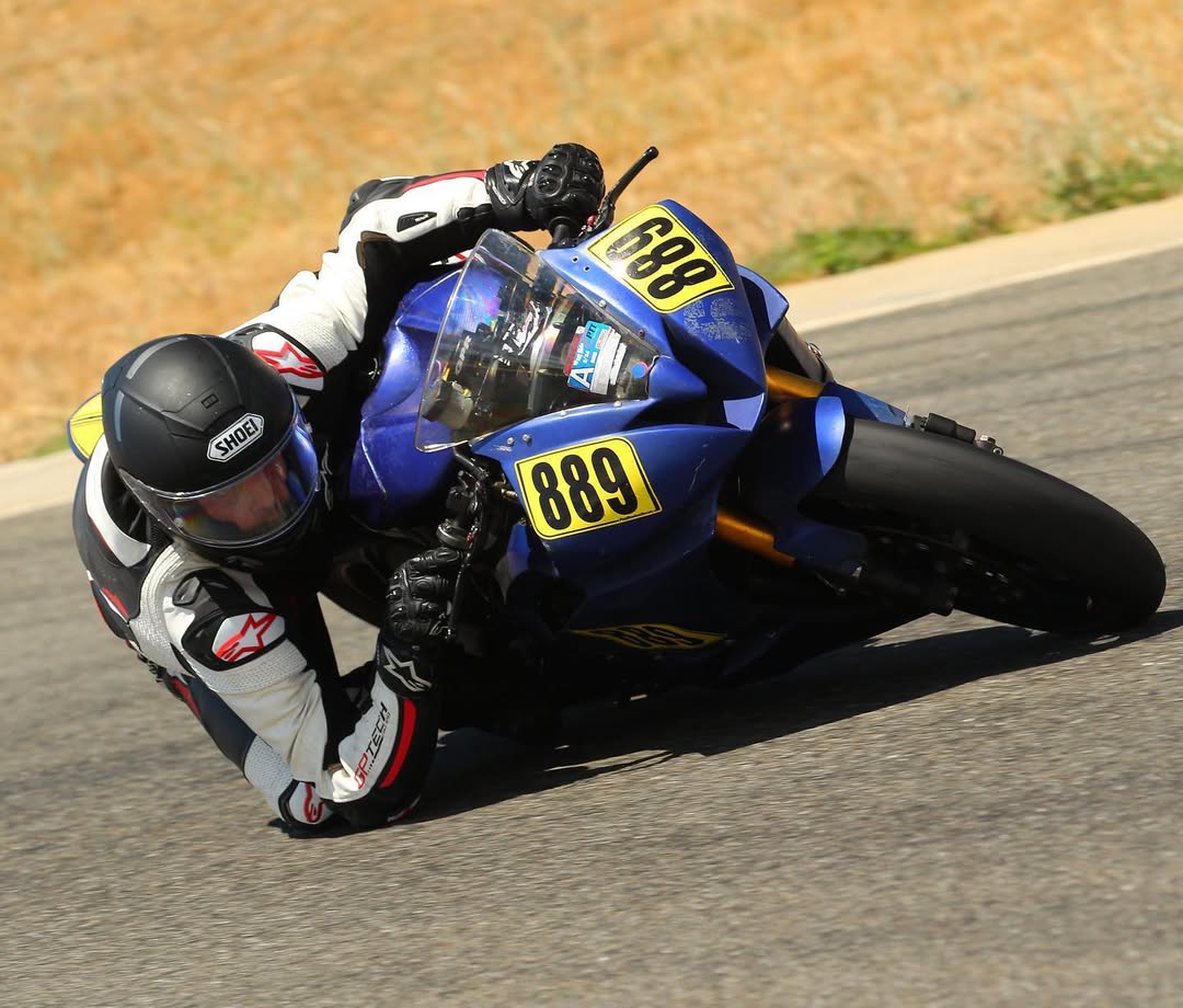 Rob Corsi leaning his motorcycle into a turn, elbow down at Thunderhill Raceway